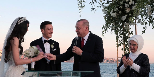 Turkey's President Recep Tayyip Erdogan speaks to Turkish-German soccer player Mesut Ozil and his wife Amine Gulse during a wedding ceremony over the Bosporus in Istanbul, Friday, June 7, 2019. (Presidential Press Service via AP, Pool)