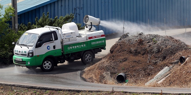 In this June 3, 2019, photo, health officials spray disinfectant solution as a precaution against African swine fever near a pig farm in Incheon, South Korea.