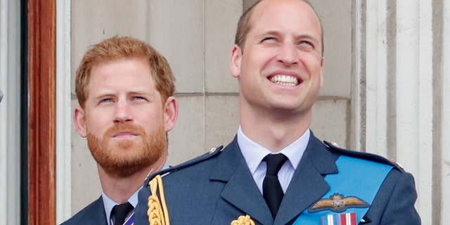 Prince Harry (left) and his older brother Prince William watch a flypast to mark the centenary of the Royal Air Force from the balcony of Buckingham Palace on July 10, 2018, in London, England. The 100th birthday of the RAF, which was founded on 1 April 1918, was marked with a centenary parade with the presentation of a new Queen's Colour and a flypast of 100 aircraft over Buckingham Palace.