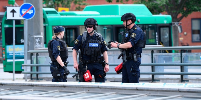Police officers attend the scene after police shot and wounded a man at Malmo central station, Sweden, Monday June 10, 2019.