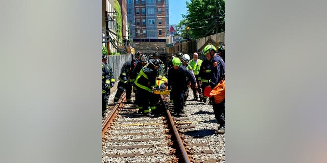 This photo provided by the Boston Fire Department, Firefighters and EMT personnel carry an injured person after a train car derailed in Boston on Saturday. Officials with the Massachusetts Bay Transportation Authority said the accident occurred at about 11 a.m. Saturday when a Green Line subway car derailed in a tunnel near Kenmore Square. Officials said several people were injured but none of the injuries are life-threatening. The cause of the derailment is under investigation. (Boston Fire Dept. via AP)
