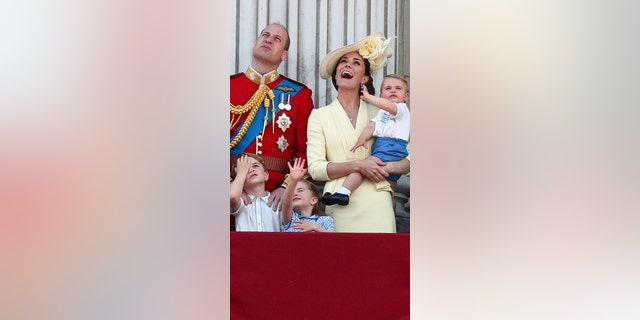 Prince William, Catherine, Duchess of Cambridge, Prince George, Princess Charlotte and Prince Louis, watch as the Royal Air Force Aerobatic Team Red Arrows performs