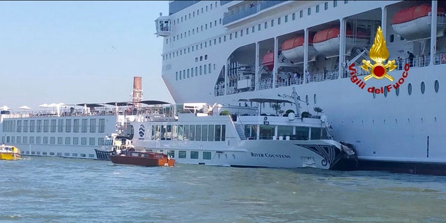 In this photo released by the Italian Firefighters, the MSC Opera cruise liner, a towering cruise ship, strikes a tourist river boat, left, Sunday, June 2, 2019, in Venice, Italy, injuring at least five people.