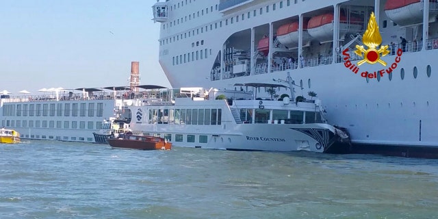 In this photo released by the Italian Firefighters, the MSC Opera cruise liner, a towering cruise ship, strikes a tourist river boat, left, Sunday, June 2, 2019, in Venice, Italy, injuring at least five people.