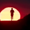 A man runs on a path as the sun rises in Frankfurt, Germany, June 27, 2019.