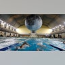 Swimmers practice as the installation 'Museum of the Moon', a seven meters diameter reproduction of the moon by British artist Luke Jerramche, is suspended above the Cozzi swimming pool in Milan, Italy, June 15, 2019. 