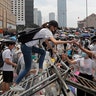 Protestors climb over barricades near the Legislative Council in Hong Kong, June 12, 2019. 