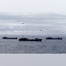 War ships and blimps carrying soldier travel to Normandy, France
