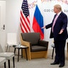 President Donald Trump gestures as Russian President Vladimir Putin arrives for talks during a bilateral meeting on the sidelines of the G-20 summit in Osaka, Japan, June 28, 2019.