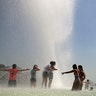 Youngsters cool off at the Trocadero public fountain in Paris, June 26, 2019. 