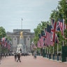 National flags of Britain and the U.S. lining the thoroughfare leading to the gilded Queen Victoria Monument in front of Buckingham Palace in London.
