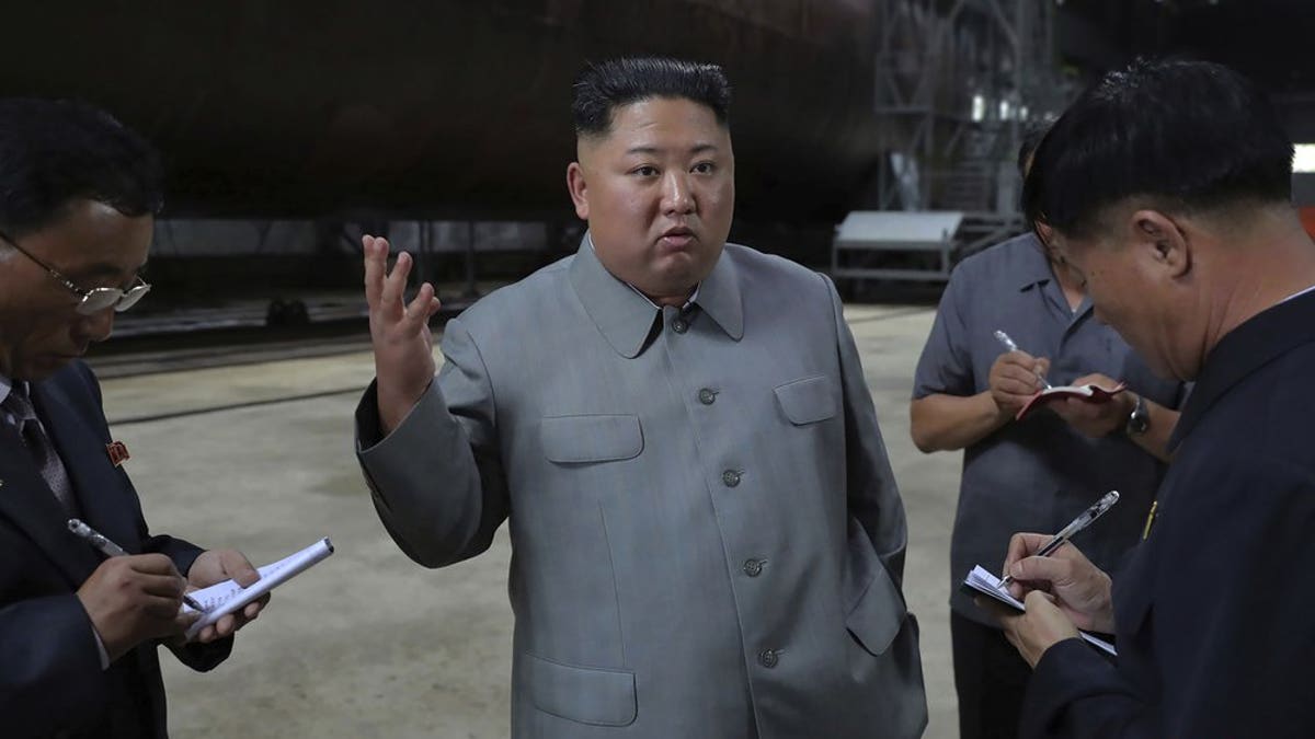 In this undated photo provided on Tuesday, July 23, 2019, by the North Korean government, North Korean leader Kim Jong Un, center, speaks while inspecting a newly built submarine to be deployed soon, at an unknown location in North Korea.