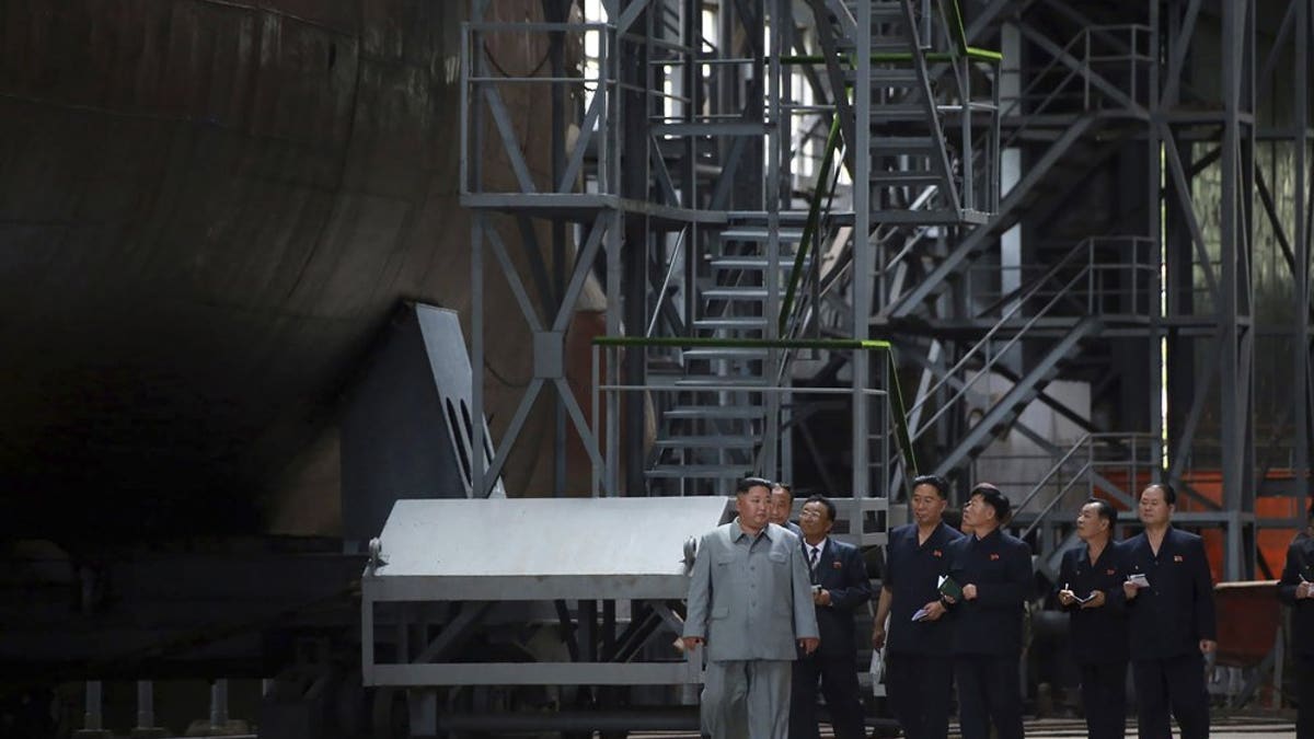 In this undated photo provided on Tuesday, July 23, 2019, by the North Korean government, North Korean leader Kim Jong Un, left, inspects a newly built submarine to be deployed soon, at an unknown location in North Korea.