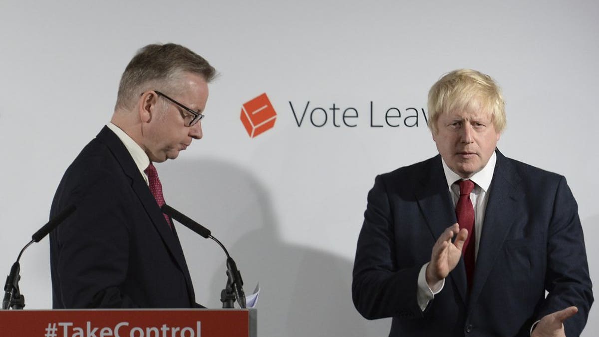 FILE - In this Friday June 24, 2016 file photo Vote Leave campaigners Michael Gove, left, leaves the lectern as Boris Johnson applauds at a press conference at Vote Leave headquarters in London.