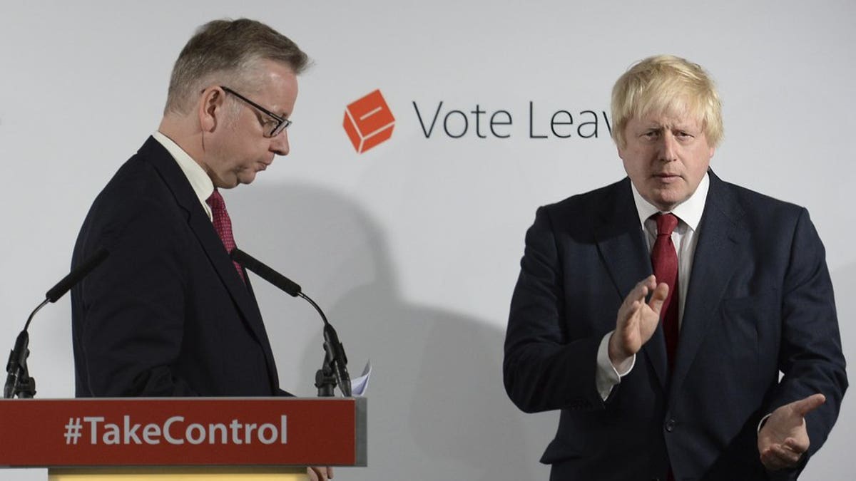 FILE - In this Friday June 24, 2016 file photo Vote Leave campaigners Michael Gove, left, leaves the lectern as Boris Johnson applauds at a press conference at Vote Leave headquarters in London.