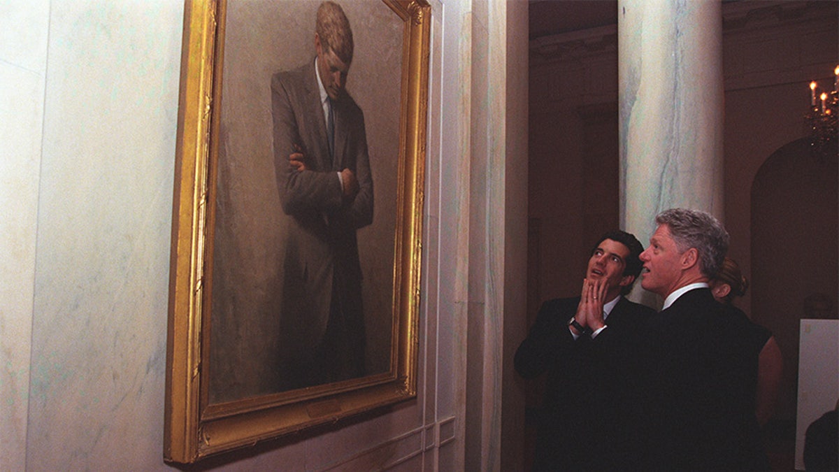President Clinton takes John F. Kennedy Jr. and Carolyn Bessette for a White House tour where they stop and admire President Kennedy’s portrait.