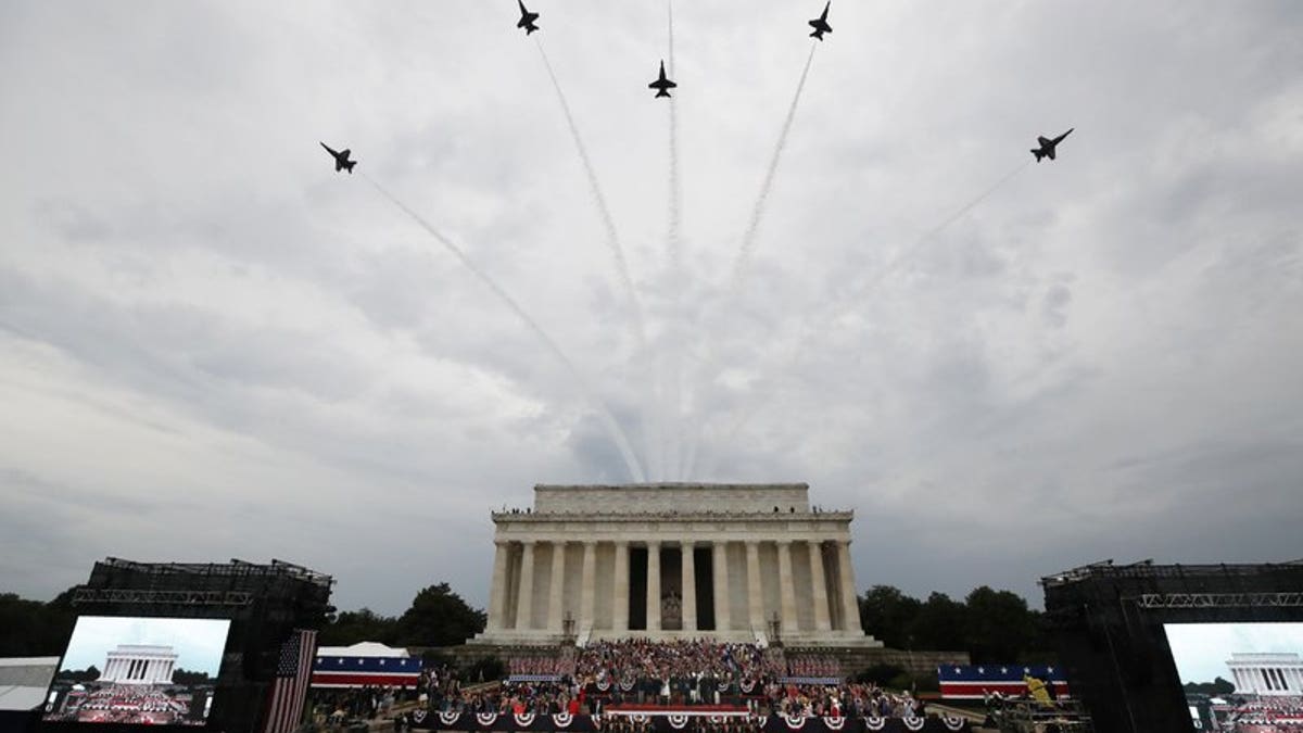 President Donald Trump, first lady Melania Trump, Vice President Mike Pence and Karen Pence and others stand as the US Army Band performs and the US Navy Blue Angels flyover at the end of an Independence Day celebration in front of the Lincoln Memorial, Thursday, July 4, 2019, in Washington.