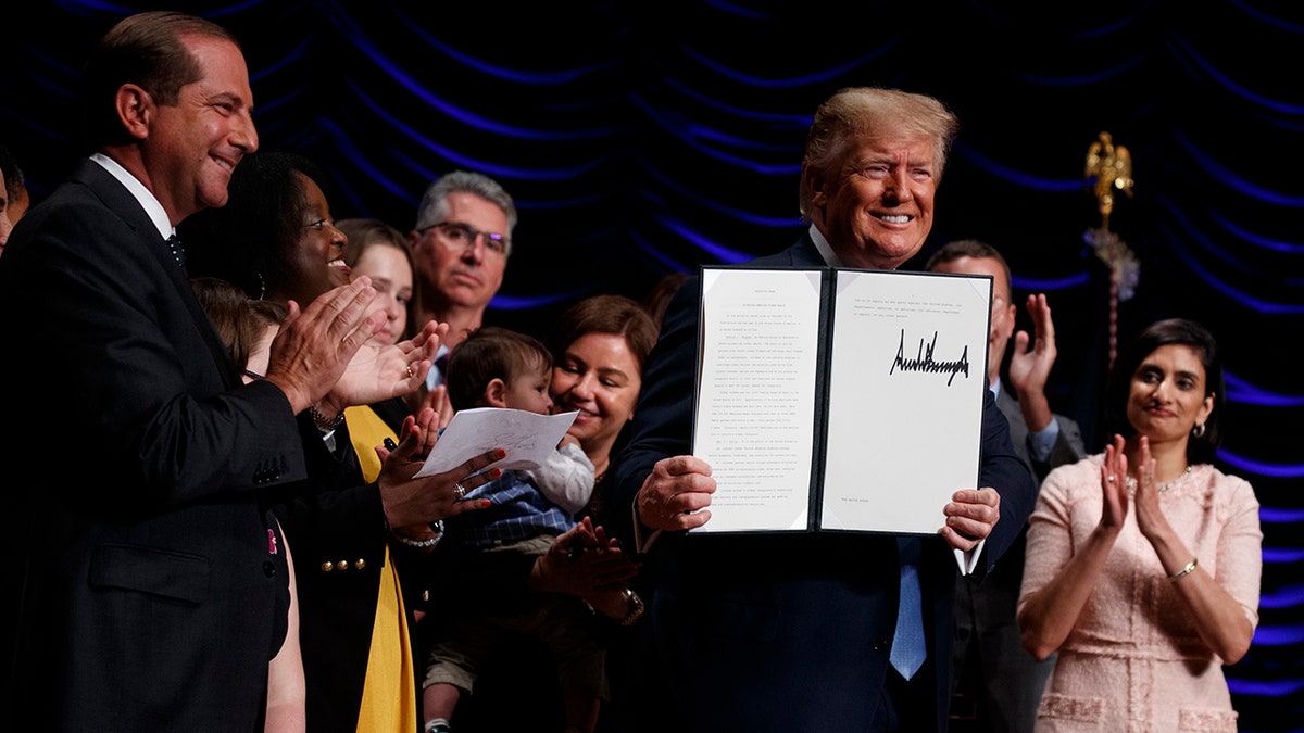 President Donald Trump holds up an executive order on kidney disease care during an event at the Ronald Reagan Building and International Trade Center, Wednesday, July 10, 2019, in Washington. (AP Photo/Evan Vucci)