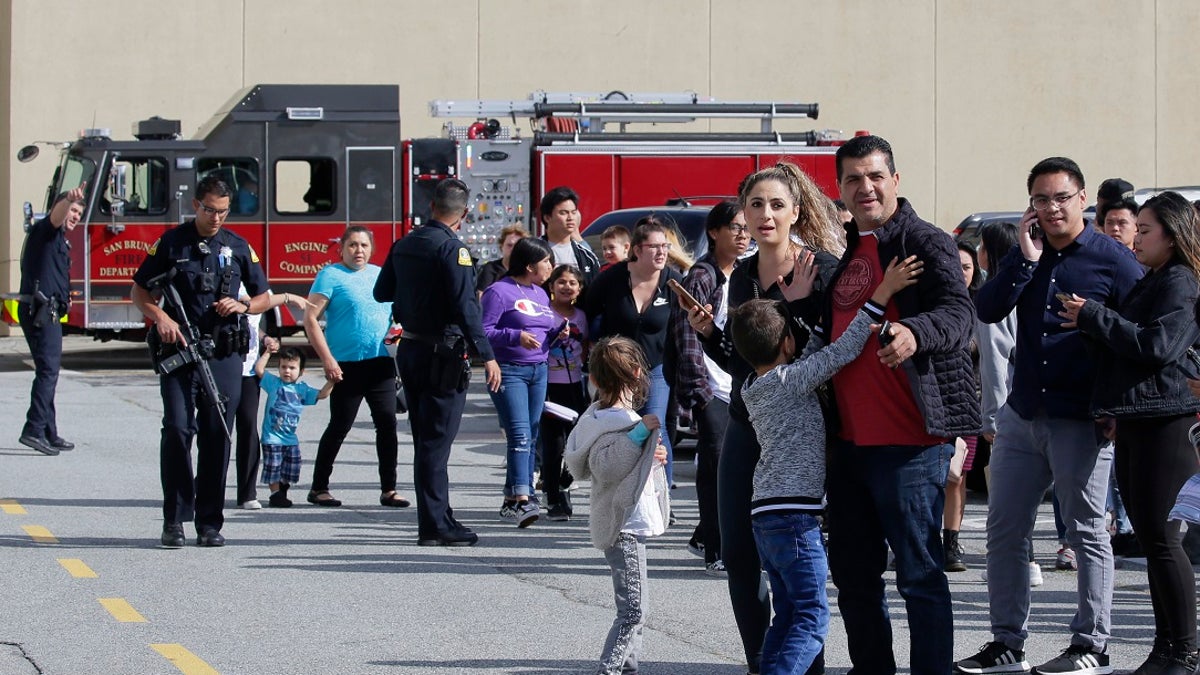 Shoppers hug after being escorted from the Tanforan Mall in San Bruno, Calif., Tuesday, July 2, 2019. Police are searching for suspects after at least two people were wounded in a mall shooting near San Francisco on Tuesday that led to region-wide transit delays at rush hour. (AP Photo/Stephanie Mullen)