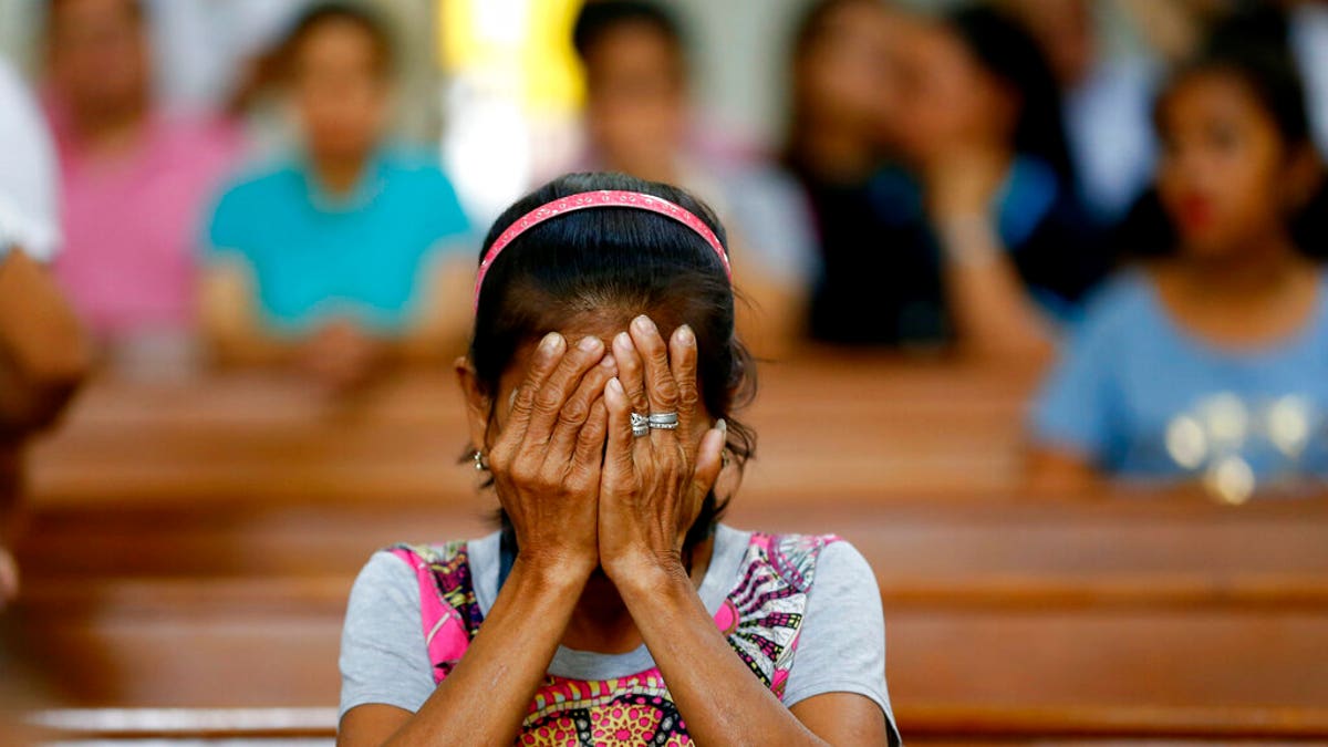 In this Mach 17, 2019, file photo, a relative of a victim in President Rodrigo Duterte's so-called war on drugs reacts during a church service in Manila, Philippines. On Thursday, July 4, 2019, the Commission on Human Rights has condemned the killing of a three-year-old girl in a crossfire in a Philippine police raid in which her father, a drug suspect, was gunned down along with another civilian and a police officer.