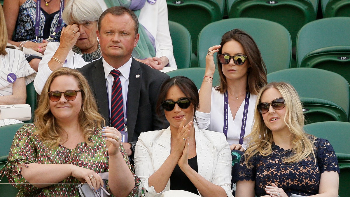 Meghan, Duchess of Sussex, center, applauds from her seat on Court Number One during day four of the Wimbledon Tennis Championships. (AP Photo/Tim Ireland)