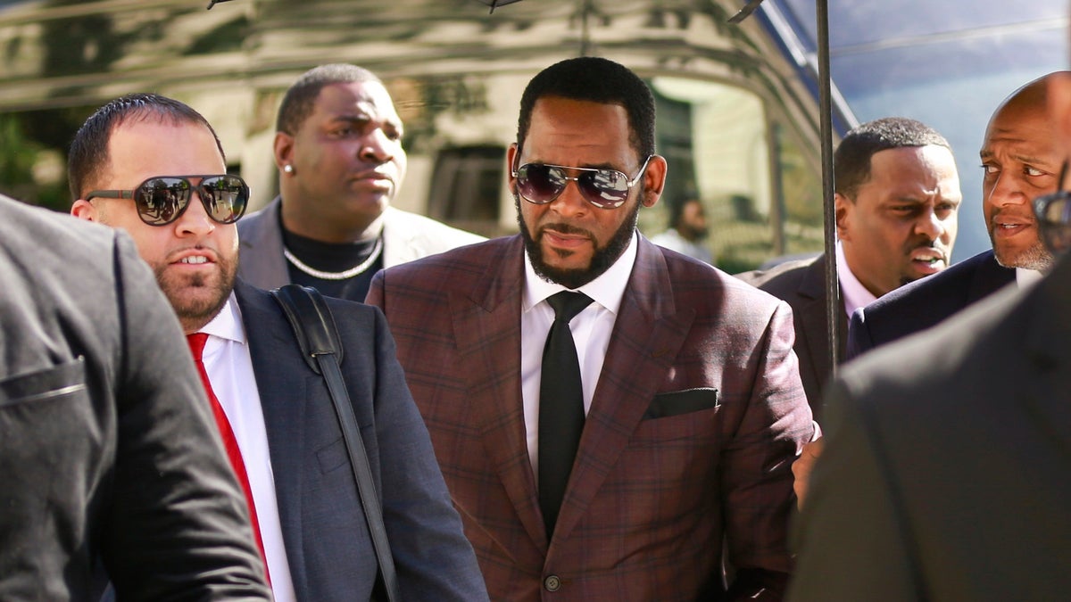 R&amp;B singer R. Kelly, center, arrives at the Leighton Criminal Court building for an arraignment on sex-related felonies in Chicago.