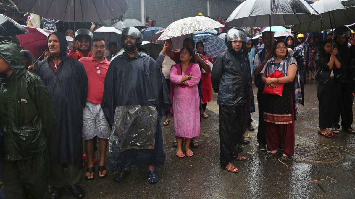 Nepalese people watch army soldiers rescuing people from their flooded homes in Kathmandu on Friday. (AP Photo/Niranjan Shrestha)