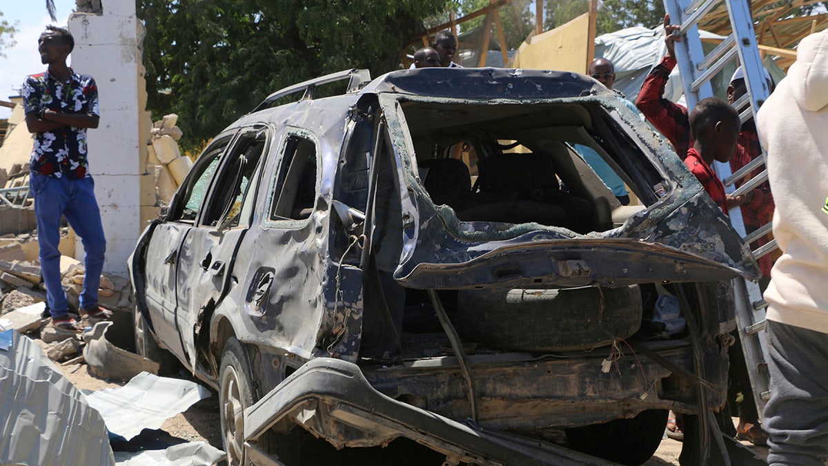 A view of a car destroyed during an attack at the Asasey Hotel, in Kismayo, Somalia, Saturday July 13, 2019. At least 10 people, including two journalists, were killed in an extremist attack Friday on a hotel in the port city of Kismayo, a Somali official said. The attack started with a suicide car bomb blast and then gunmen stormed into the hotel. (AP Photo)