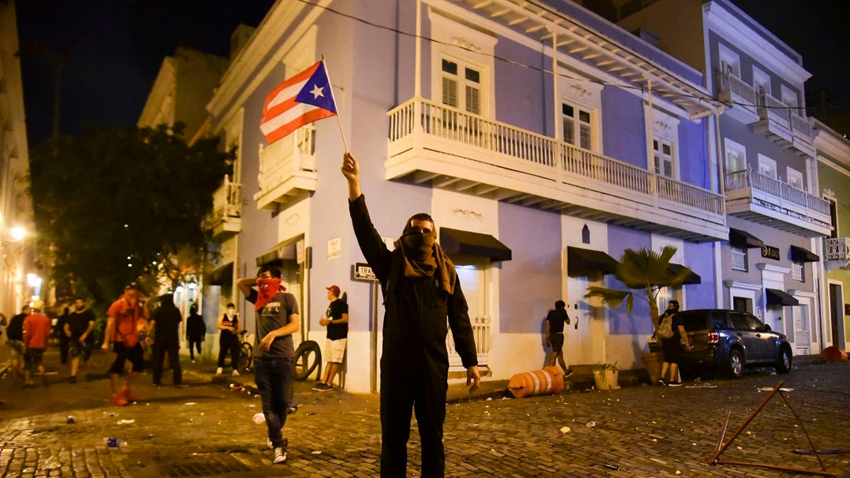 Citizens riot near the executive mansion demanding the resignation of Gov. Ricardo Rossello on Monday. (AP Photo/Carlos Giusti)
