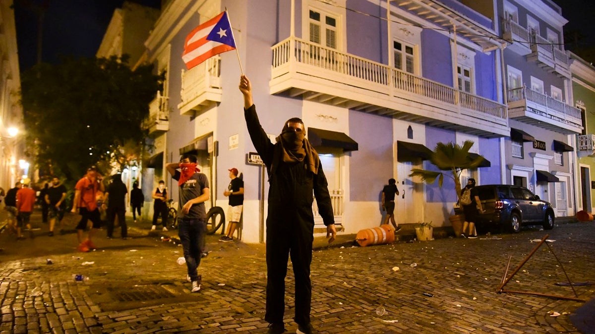 Citizens riot near the executive mansion demanding the resignation of Gov. Ricardo Rossello on Monday. (AP Photo/Carlos Giusti)
