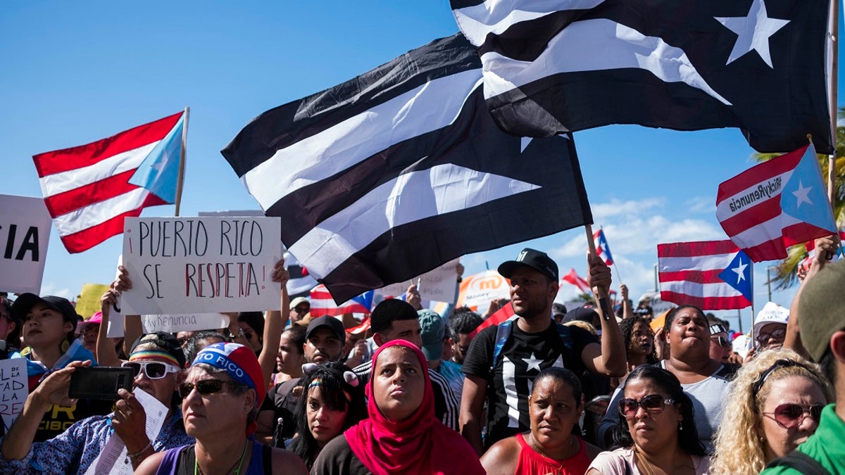 Demonstrators march in San Juan Wednesday (AP Photo/Dennis M. Rivera Pichardo)