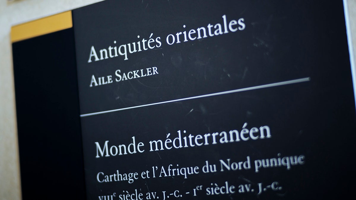 A sign reads "Oriental Antiquities, Sackler wing" at the Louvre Museum in Paris, France, Wednesday, July 17, 2019. France's Louvre museum has taped over the Sackler name as donors to a wing of the building after protests against the family blamed for the opioid crisis in the United States. (AP Photo/Kamil Zihnioglu)