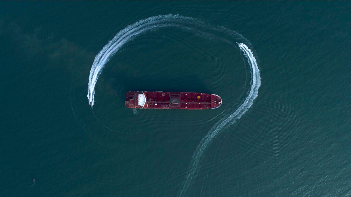 In this Sunday, July 21, 2019 photo, an aerial view shows a speedboat of Iran's Revolutionary Guard moving around the British-flagged oil tanker Stena Impero which was seized in the Strait of Hormuz on Friday by the Guard, in the Iranian port of Bandar Abbas. Global stock markets were subdued Monday while the price of oil climbed as tensions in the Persian Gulf escalated after Iran's seizure of a British oil tanker on Friday. (Morteza Akhoondi/Tasnim News Agency via AP)