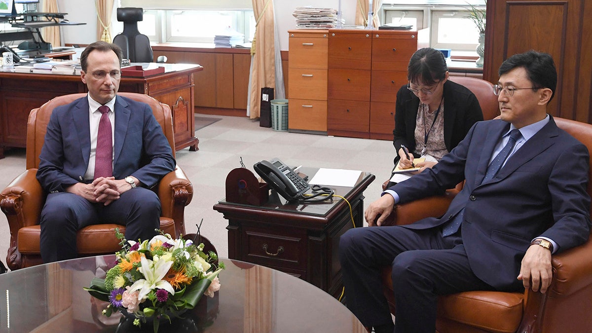 Acting Russian Ambassador to South Korea Maxim Volkov, left, and South Korean Deputy Minister for Political Affairs Yoon Soon-gu take their seats before their meeting at the Foreign ministry in Seoul, South Korea, Tuesday, July 23, 2019. Yoon on Tuesday summoned Volkov to protest the countries' military jets entering South Korea's airspace. (Kim Sung-do/Yonhap via AP)
