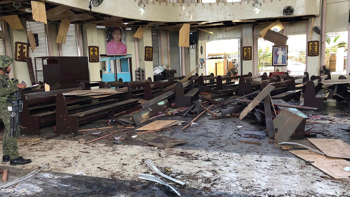In this Jan. 27, 2019, file photo provided by WESMINCOM Armed Forces of the Philippines, a soldier views the site inside a Roman Catholic cathedral in Jolo, the capital of Sulu province in the southern Philippines, after two bombs exploded. Police said Tuesday, July 23, 2019, they believe an Indonesian husband and wife carried out the suicide bombing of a cathedral in the southern Philippines in January that killed more than 20 people.