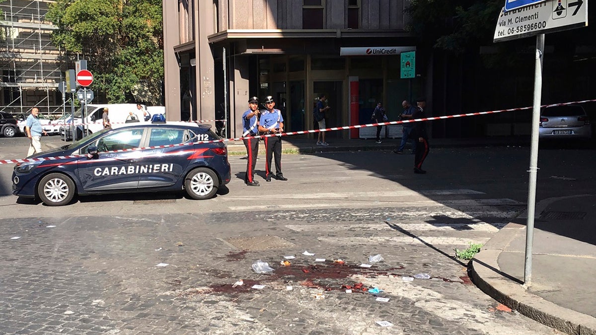 Two Italian Carabinieri, paramilitary police officers, stand near a blood stain, the site where their colleague, Carabiniere Vice Brigadier Mario Cerciello Rega, was stabbed to death by a thief in Rome. (Associated Press)