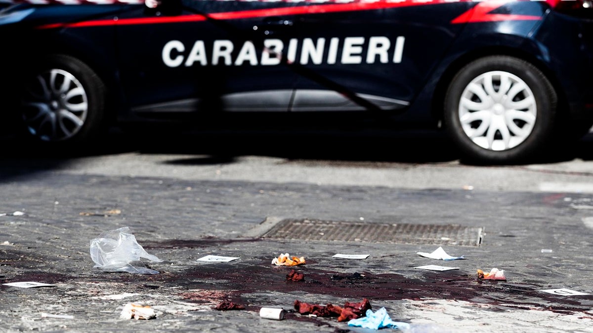 A car of the Italian Carabinieri, paramilitary police, is parked near a blood stain, the site where Carabiniere Vice Brigadier Mario Cerciello Rega was stabbed to death by a thief in Rome on Friday. (Angelo Carconi/ANSA Via AP)