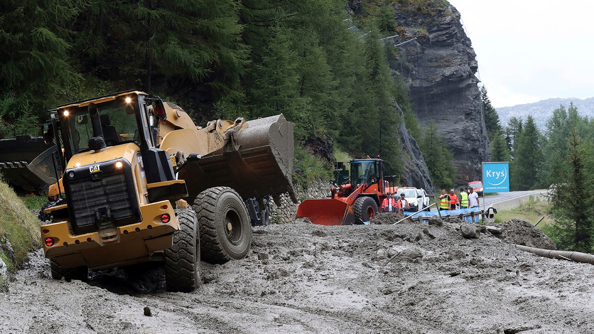 Worker use diggers to clean the road of the nineteenth stage of the Tour de France cycling race over 126,5 kilometers (78,60 miles) with start in Saint Jean De Maurienne and finish in Tignes, France, Friday, July 26, 2019. Organizers stopped the world's premier cycling event Friday for the riders' safety when a sudden, violent storm made the route through the Alps too dangerous. (AP Photo/Thibault Camus)