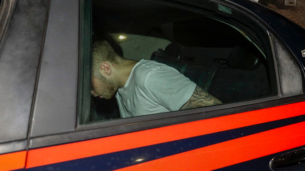 A man who was allegedly questioned in the case of a slain Carabinieri policeman is seen on a Carabinieri car as it leaves a police station, in Rome, early Saturday morning, July 27, 2019. A young American tourist has confessed to fatally stabbing an Italian paramilitary policeman who was investigating the theft of a bag and cellphone before dawn Friday, the Italian news agency ANSA and state radio reported. (AP Photo/Andrew Medichini)