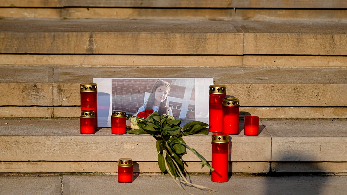 Flowers and candles placed in memory of the 15-year-old girl outside the Interior Ministry in Bucharest, Romania, on Friday. (AP Photo/Andreea Alexandru)