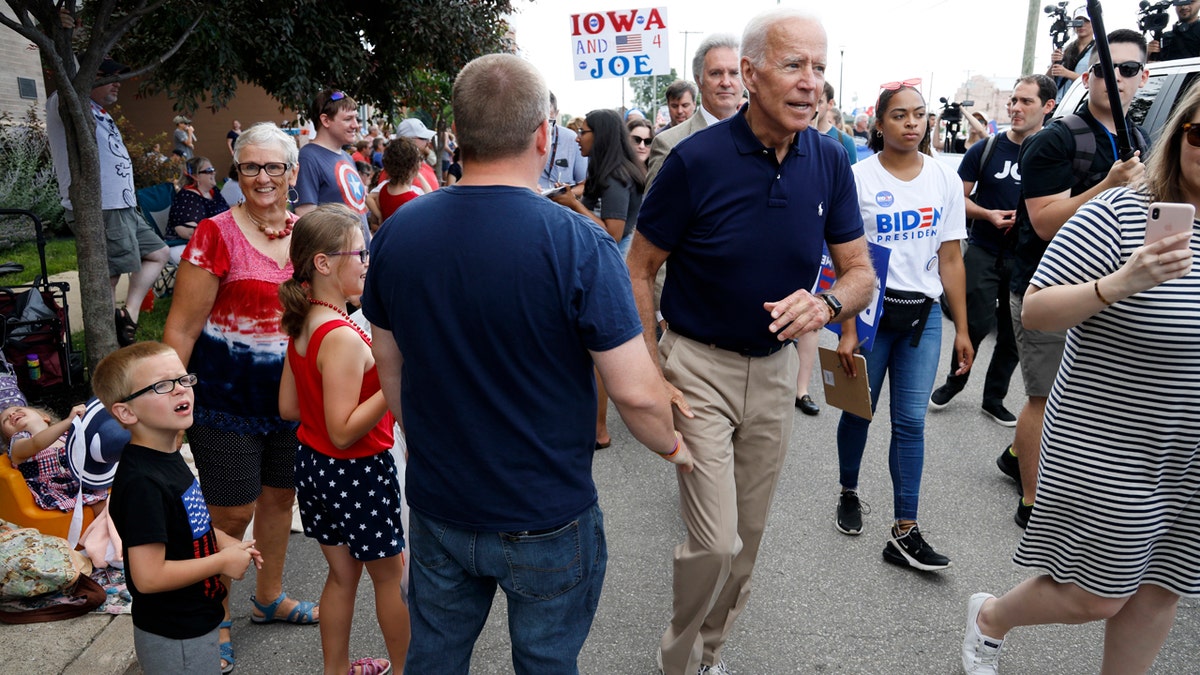 Former Vice President and Democratic presidential candidate Joe Biden greets local residents while walking in the Independence Fourth of July parade on Thursday in Independence, Iowa. (AP Photo/Charlie Neibergall)