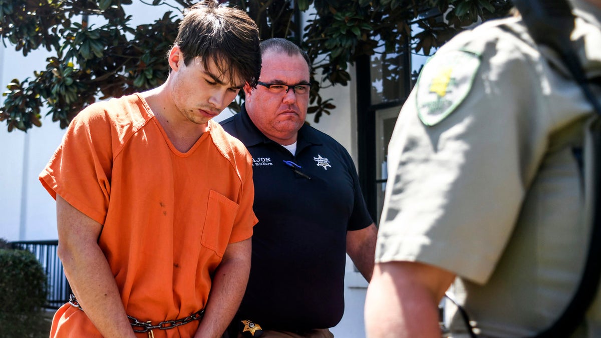 Brandon Theesfeld, left, is led from the Lafayette County Courthouse in Oxford, Miss., Tuesday, July 23, 2019 by Maj. Alan Wilburn.