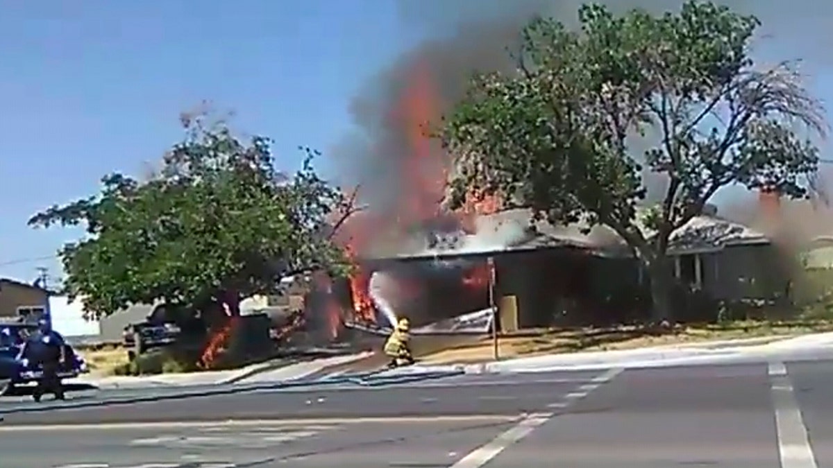 In this image taken from video provided by Ben Hood, a firefighter works to extinguish a fire, Thursday, July 4, 2019, following an earthquake in Ridgecrest, Calif. (Ben Hood via AP)