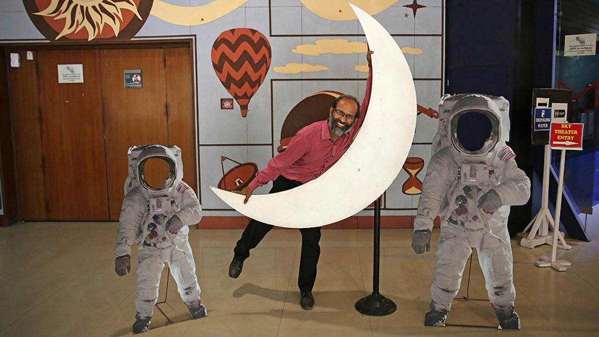 An employee playfully hugs a cut-out of a crescent moon at the Nehru Planetarium in New Delhi, India, Thursday, July 11, 2019. India is looking to take a giant leap in its space program and solidify its place among the world’s spacefaring nations with its second unmanned mission to the moon, this one aimed at landing a rover near the unexplored south pole. (AP Photo/Altaf Qadri)