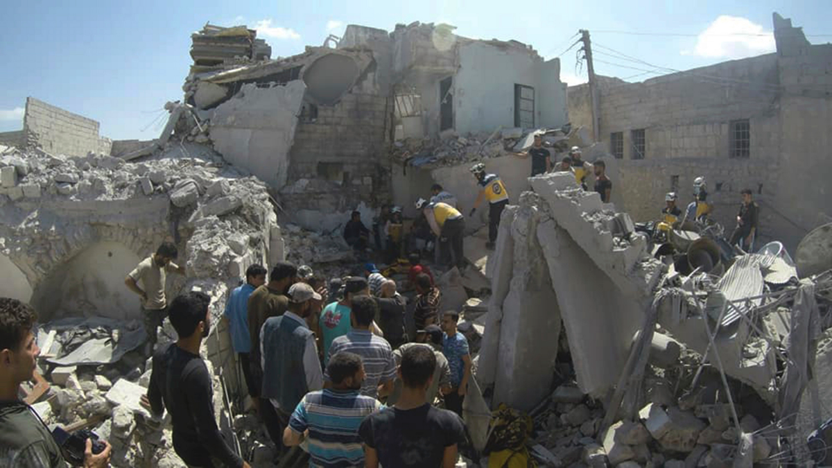 This photo provided by the Syrian Civil Defense White Helmets, which has been authenticated based on its contents and other AP reporting, shows Syrian White Helmet civil defense workers searchING for victims from under the rubble of a destroyed building that hit by a Syrian government airstrike, in the northern town of Ariha, in Idlib Province, Syria, earlier this month. (Syrian Civil Defense White Helmets via AP)