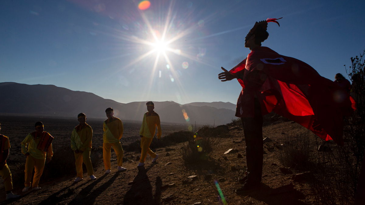 A youth dressed as a shaman arrives to take part in a photo session before Tuesday's total solar eclipse, in La Higuera, Chile, Monday, July 1, 2019.