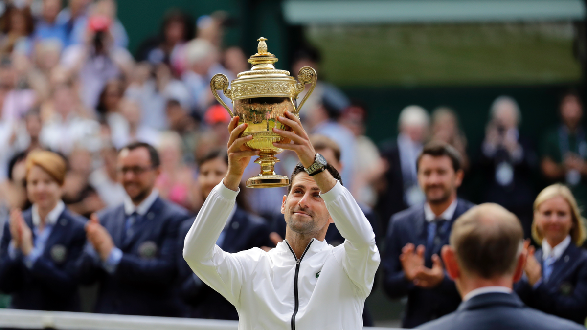 Serbia's Novak Djokovic lifts his trophy after defeating Switzerland's Roger Federer during the men's singles final match of the Wimbledon Tennis Championships in London, Sunday, July 14, 2019. (AP Photo/Ben Curtis)
