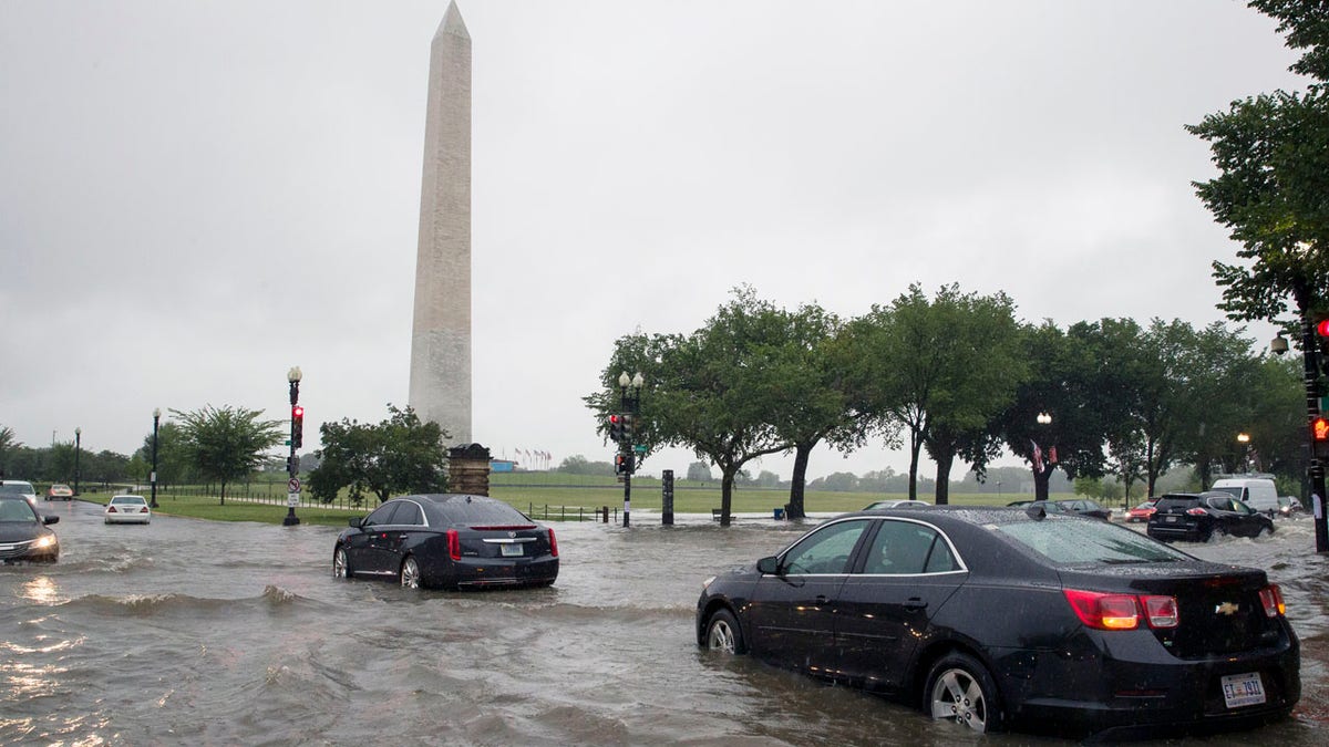 Heavy rainfall flooded the intersection of 15th Street and Constitution Ave., NW stalling cars in the street, Monday, July 8, 2019, in Washington near the Washington Monument.