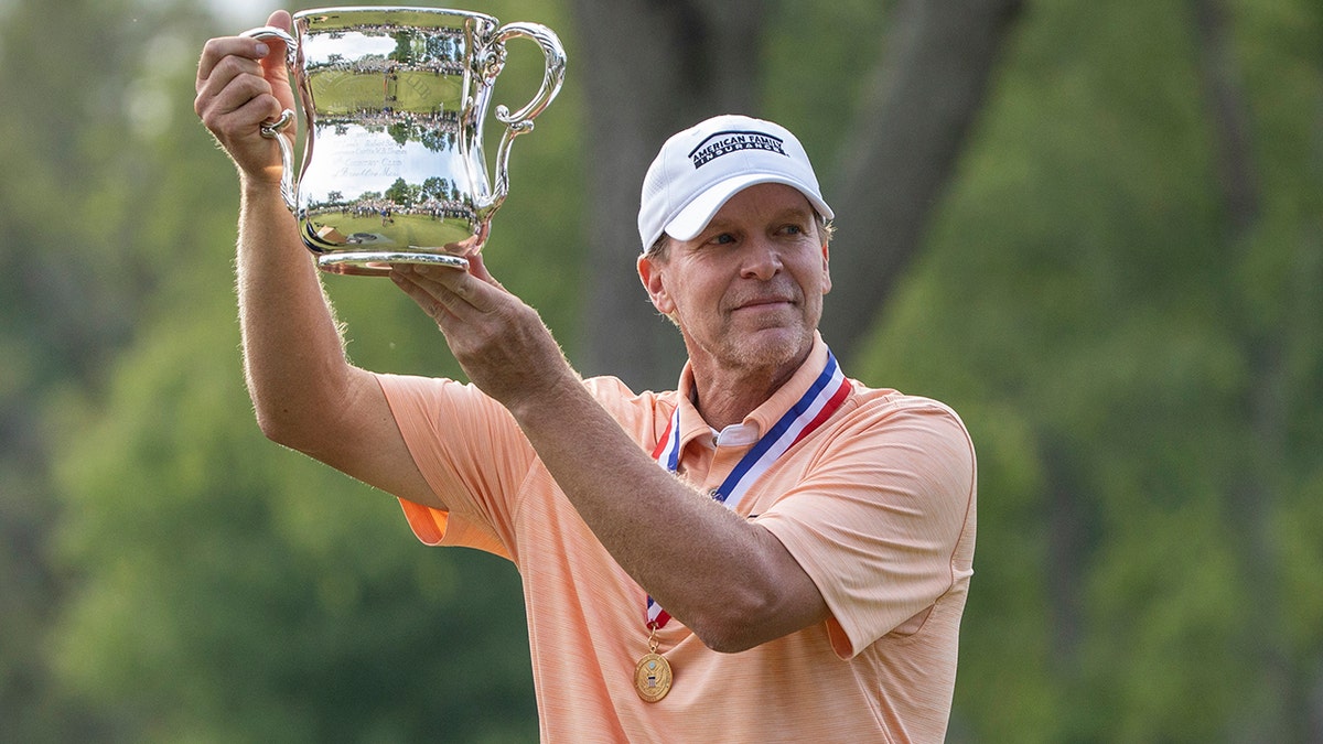 Steve Stricker hoists the championship trophy after winning the U.S. Senior Open golf tournament following the final round of play Sunday, June 30, 2019, in South Bend, Ind. (John Mersits/South Bend Tribune via AP)