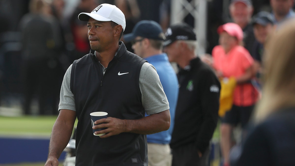 Tiger Woods of the United States holds a drink as he walks through the practice range ahead of the start of the British Open golf championships at Royal Portrush in Northern Ireland, Tuesday, July 16, 2019. The British Open starts Thursday. (AP Photo/Jon Super)